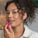 A woman applying Tropic’s Limited Edition Lip Love balm to her lips, showing a natural, glowing makeup look with hydrated, glossy lips.